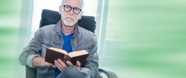 Olgun adam evde kitap okurken portresi