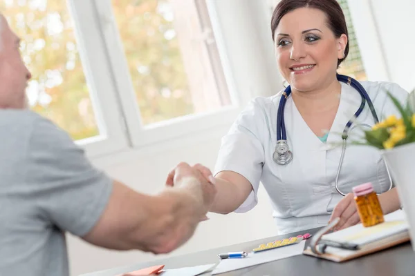 Médico Feminino Apertando Mãos Com Paciente Sênior — Fotografia de Stock