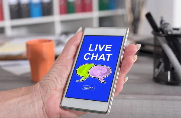 Female hand holding a smartphone with live chat concept
