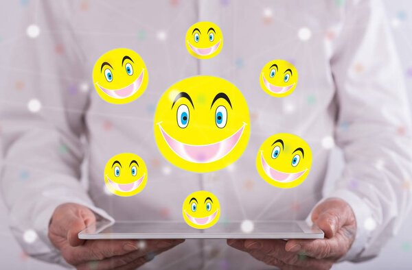 Счастливая концепция над планшетом, который держит человек в фоновом режиме
