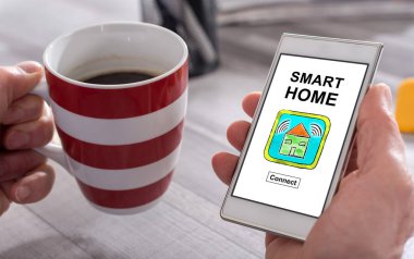 Erkek el bir smartphone akıllı ev concept ile tutarak