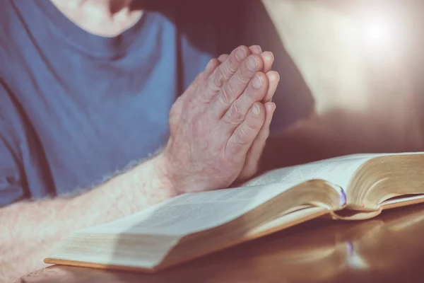 Primo Piano Dell Uomo Che Prega Con Mani Sulla Bibbia — Foto Stock