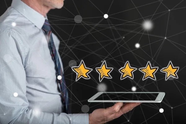 Bir adamın elinde tuttuğu tabletin üstündeki kalite konsepti.