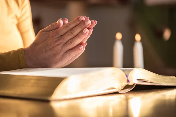 Acercamiento Mujer Rezando Con Sus Manos Sobre Biblia Luz Dura — Foto de Stock