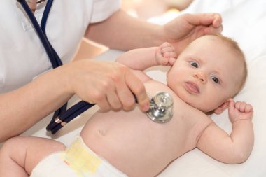 Küçük bir bebek incelemek için stetoskop kullanarak çocuk doktoru el