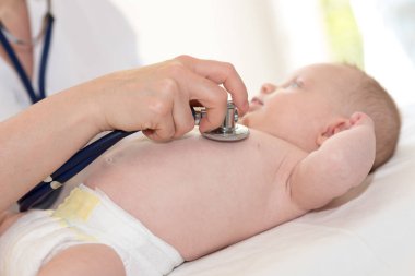 Küçük bir bebek incelemek için stetoskop kullanarak çocuk doktoru el