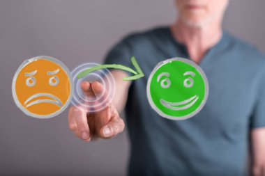 Bir adam dokunmatik ekranda müşteri memnuniyeti kavramına parmağıyla dokunuyor.