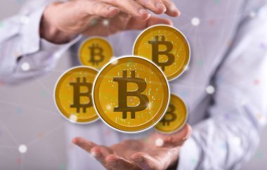 Arka planda bir adamın elleri arasında Bitcoin kavramı