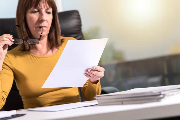 Mature Businesswoman Checking Document Office Light Effect — Stock Photo, Image
