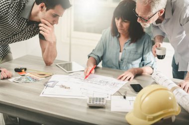 Ofiste planlar üzerinde çalışan mimarlar, ışık efektleri