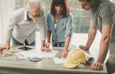 Planları ofiste çalışan mimarlar