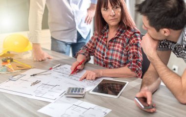Ofiste planlar üzerinde çalışan mimarlar, ışık efektleri