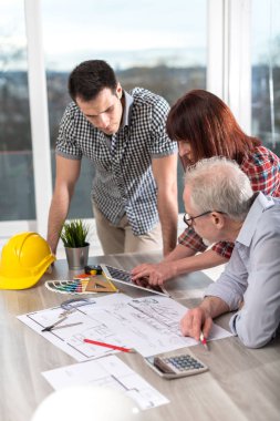 Planları ofiste çalışan mimarlar
