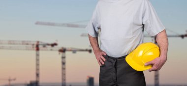 Bina işçisi kask bir inşaat site arka plan ile