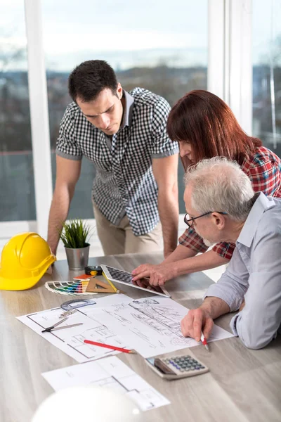 Planları ofiste çalışan mimarlar