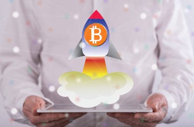 Bitcoin yükselişi kavramı üzerinde arka planda bir adam tarafından düzenlenen bir tablet