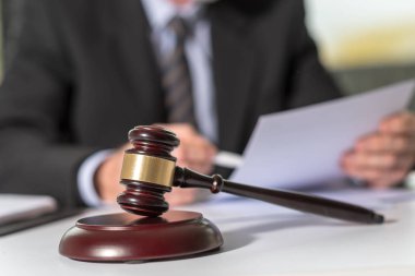 Yargıç tokmak ile yasal belge arka planda çalışan avukat