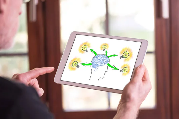タブレットを示す人間の脳のアイデア コンセプトを抱きかかえた — ストック写真