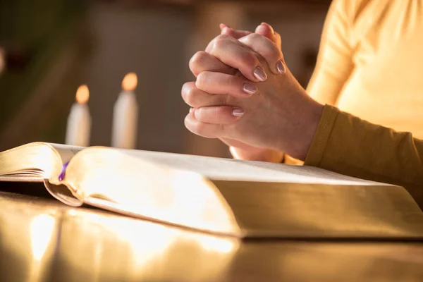 Acercamiento Mujer Rezando Con Sus Manos Sobre Biblia Luz Dura — Foto de Stock