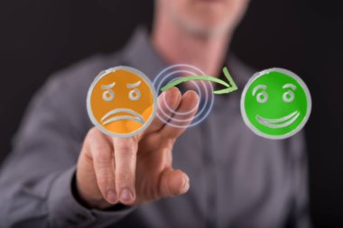 Bir adam dokunmatik ekranda müşteri memnuniyeti kavramına parmağıyla dokunuyor.