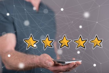 Kalite anlayışı yukarıda arka planda bir adam tarafından düzenlenen bir akıllı telefon