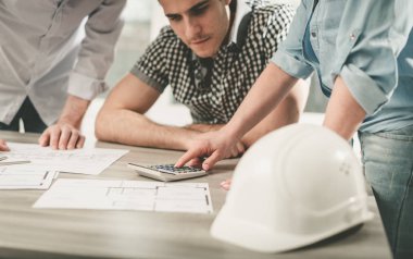 Planları ofiste çalışan mimarlar