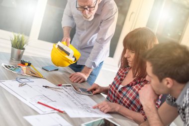 Ofiste planlar üzerinde çalışan mimarlar, ışık efektleri