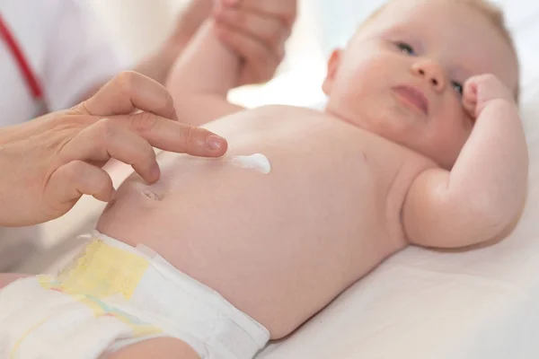 Hand Des Kinderarztes Cremt Babykörper Ein — Stockfoto