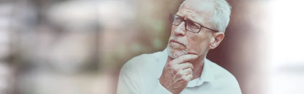 Portrait of thoughtful mature man on blurred background
