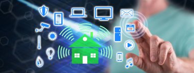 Adam dokunmatik ekranda akıllı bir ev kavramına parmağıyla dokunuyor.