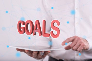 Arka planda bir adam tarafından düzenlenen bir tablet üzerinde gol kavramı