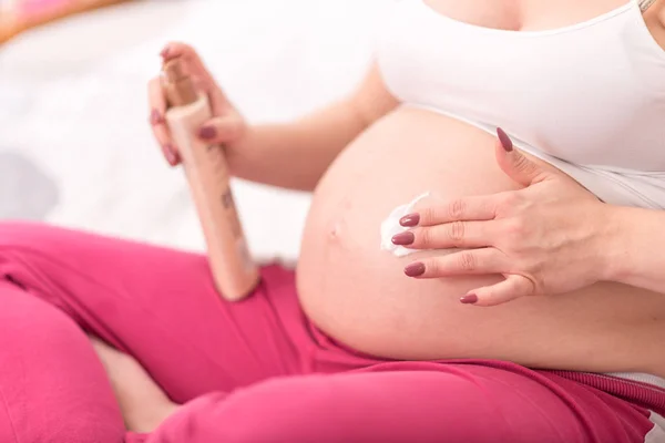 孕妇用奶油涂抹在腹部的伸展痕上 — 图库照片