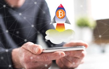 Bir akıllı telefon bitcoin artış konsepti ile tutan adamın elleri