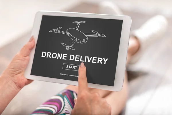Woman using a tablet with drone delivery concept
