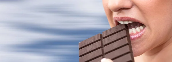 Primer Plano Mujer Mordiendo Una Barra Chocolate Sobre Fondo Borroso —  Fotos de Stock