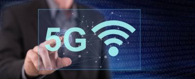 Bir adam dokunmatik ekranda 5G konseptine parmağıyla dokunuyor.