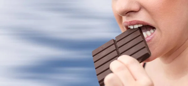 Primer Plano Mujer Mordiendo Una Barra Chocolate Sobre Fondo Borroso —  Fotos de Stock