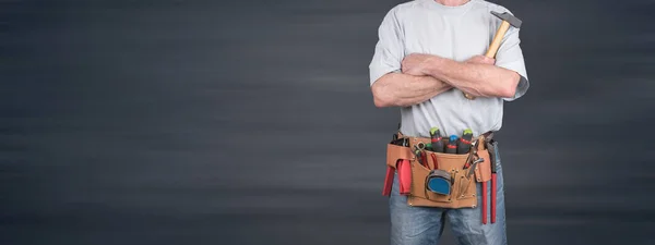 Bouwvakker met gekruiste armen en gereedschap riem — Stockfoto