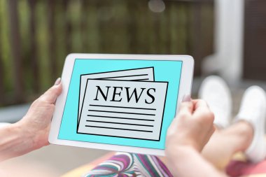 Bir tablet haber kavramı ile tutan eller