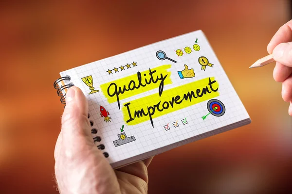 Hand drawing quality improvement concept on a notepad