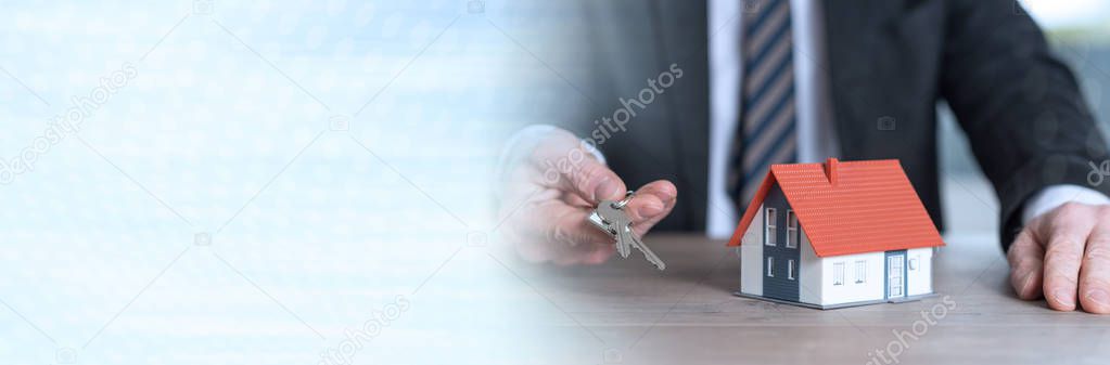 Real estate agent holding house keys, concept of home ownership. panoramic banner