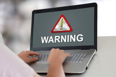 Ekranda uyarı konsepti ile bir dizüstü bilgisayar kullanan kadın