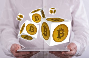 Arka planda bir adamın tuttuğu tabletin üzerinde Bitcoin kavramı
