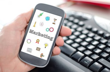 Pazarlama kavramı gösterilen bir smartphone tutan el