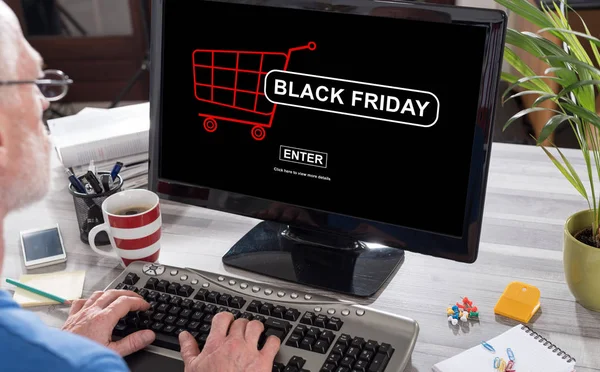 Man using a computer with black friday concept on the screen
