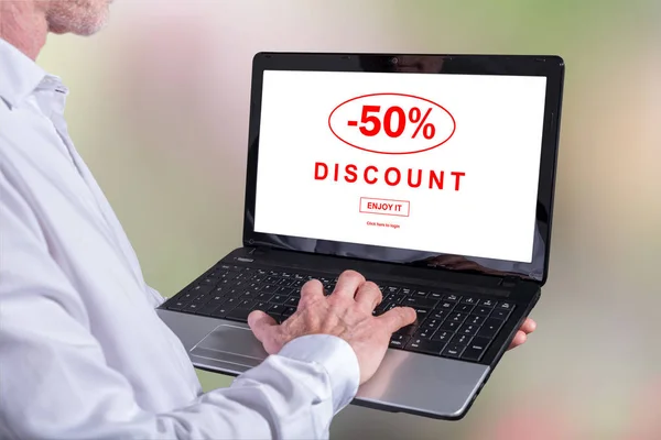 Man using a laptop with discount concept on the screen