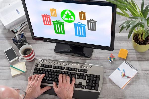 Man using a computer with recycling concept on the screen