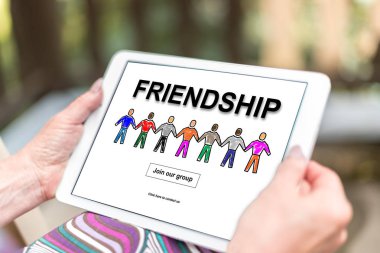 Bir tablet dostluk kavramı ile tutan eller