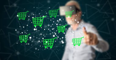Kulaklıklı bir adam dokunmatik ekranda bir e-ticaret konseptine parmağıyla dokunuyor.