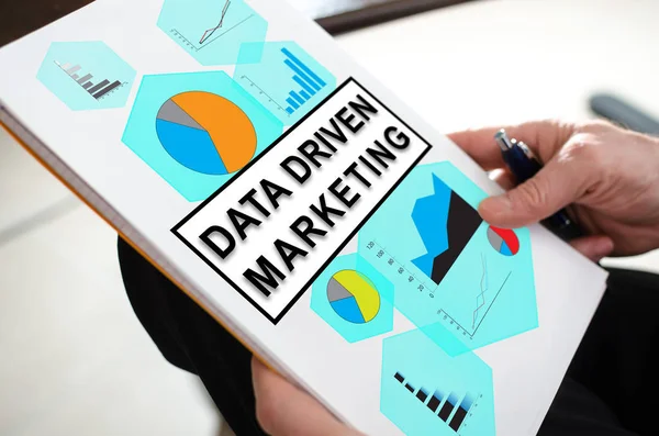 Data driven marketing concept on a paper held by a hand